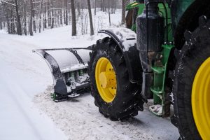 big special tractor is removing snow from forestal road 1