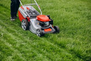 man cutting grass with lawn mover back yard 1